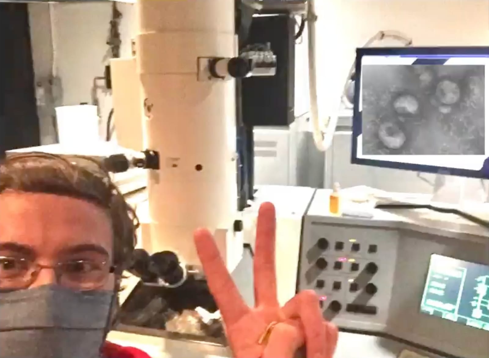 Still from SARS-CoV-2 and You: at the electron microscope, with virus particles on the monitor